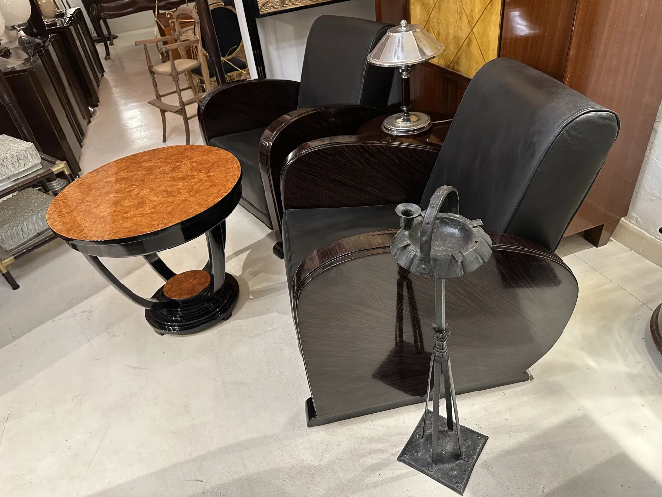 Dois poltronas antigas em um ambiente elegante, com lâmpada e mesa.