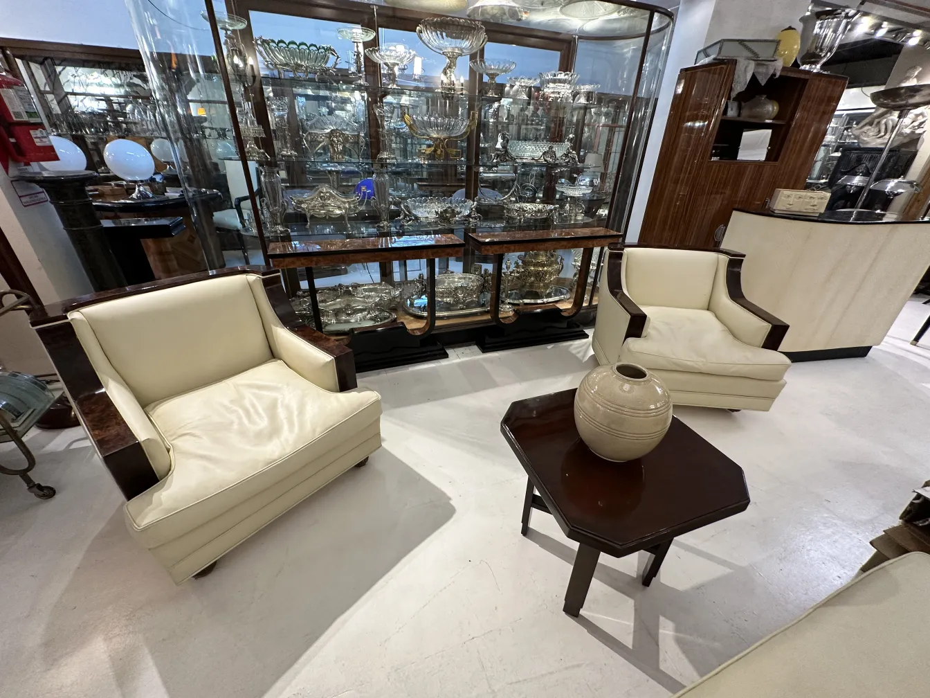 Two antique cream armchairs in a bright room