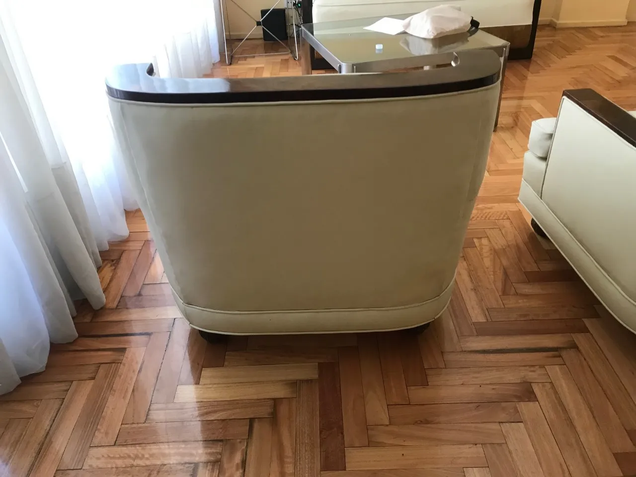 Vista posteriore di 2 poltrone antiche, con dettagli in legno e design classico, in un ambiente accogliente.