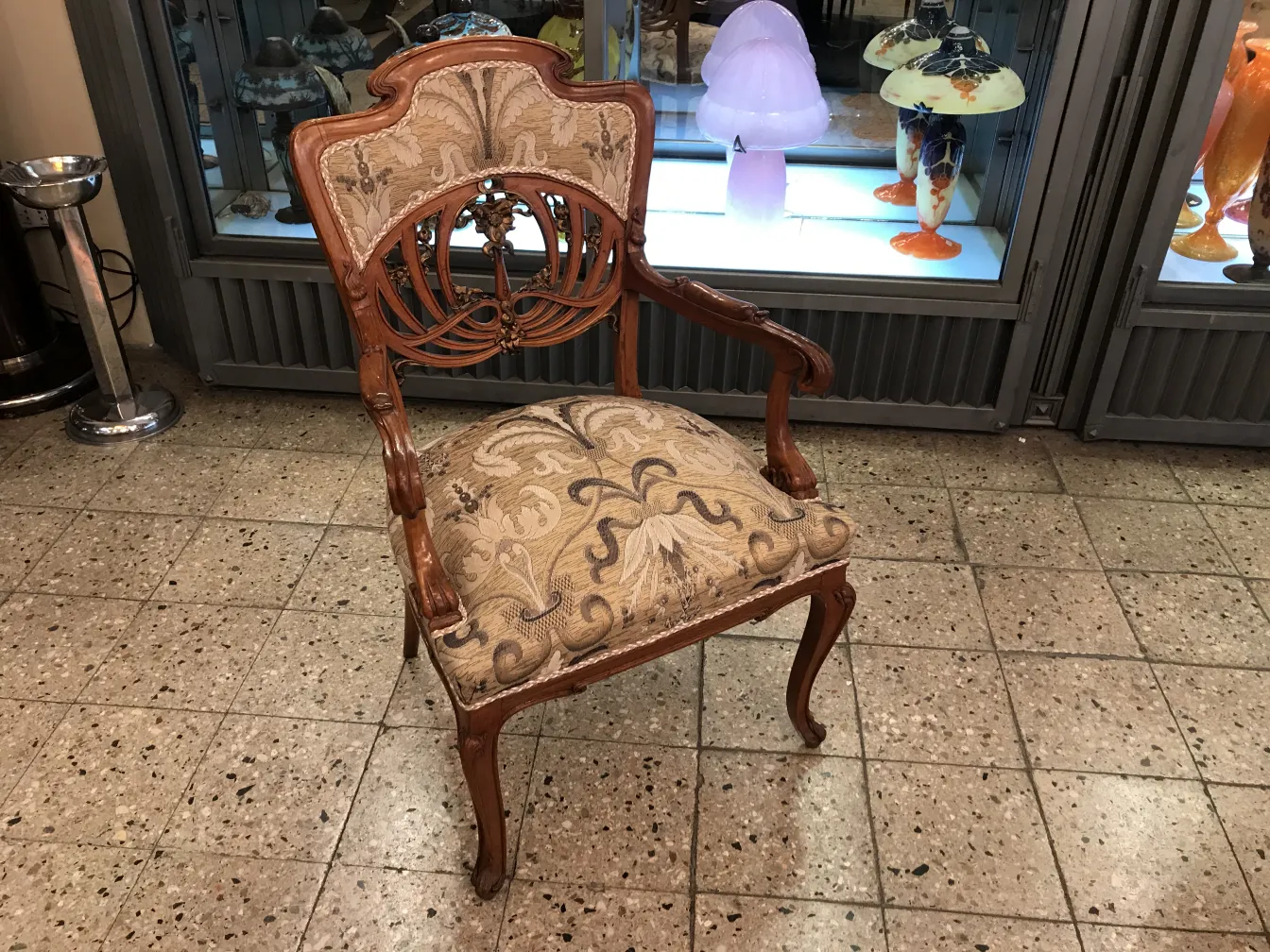 Three antique art nouveau armchairs with ornamental design in a cozy setting.