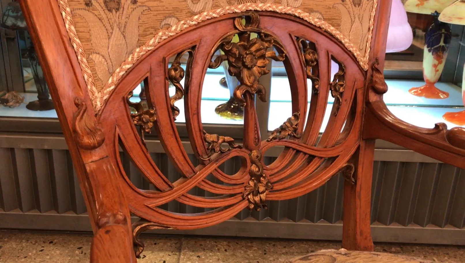 Three antique armchairs with decorative carvings on the backrest, Art Nouveau style, in a classic setting.