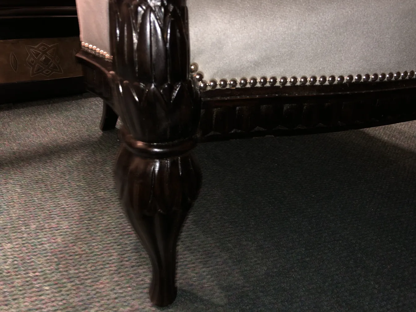 View of an antique armchair with distinctive decorative details by Paul Follot, in a cozy setting.