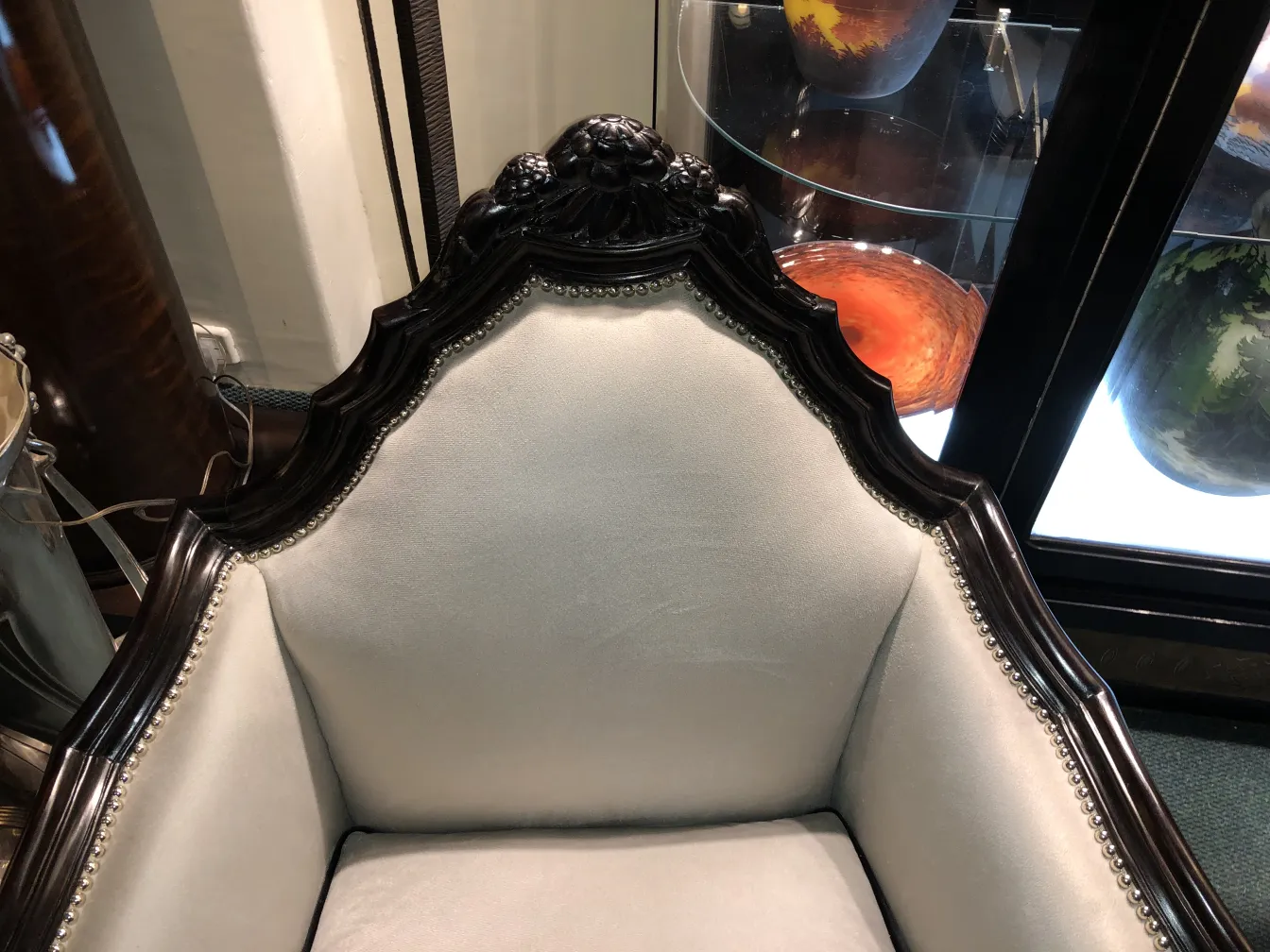 Vue de 3 fauteuils anciens au design distinctif de Paul Follot dans un environnement élégant avec des objets décoratifs.