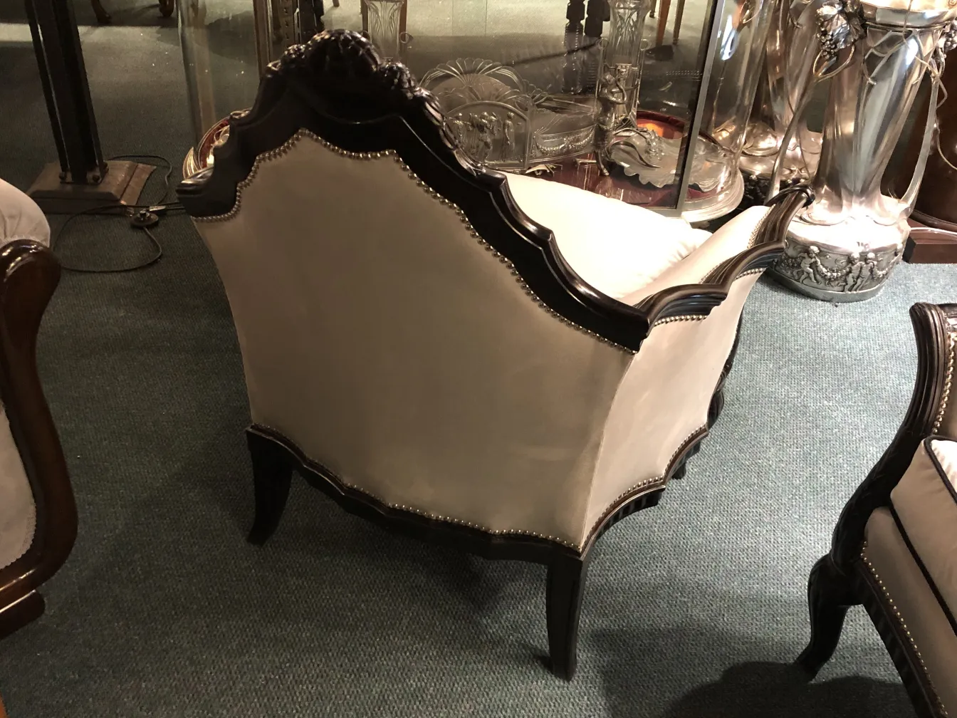 Tres sillones antiguos de estilo clásico con detalles decorativos, situados en una tienda de antigüedades.