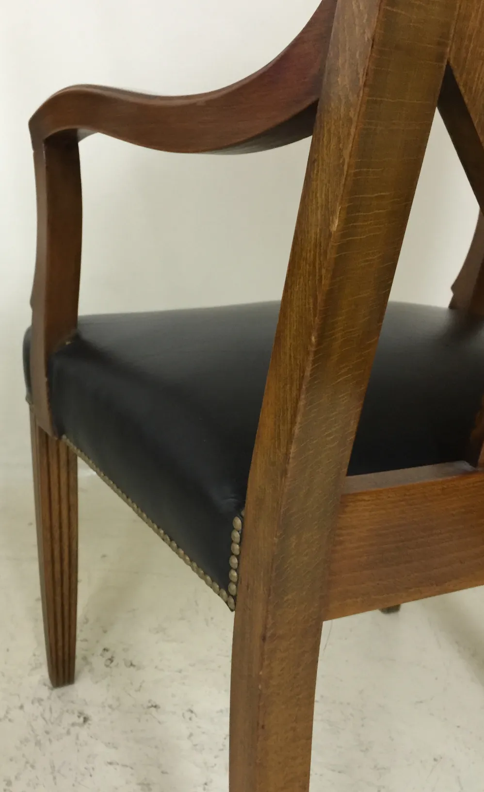Sillón de escritorio antiguo con brazos y tapizado negro