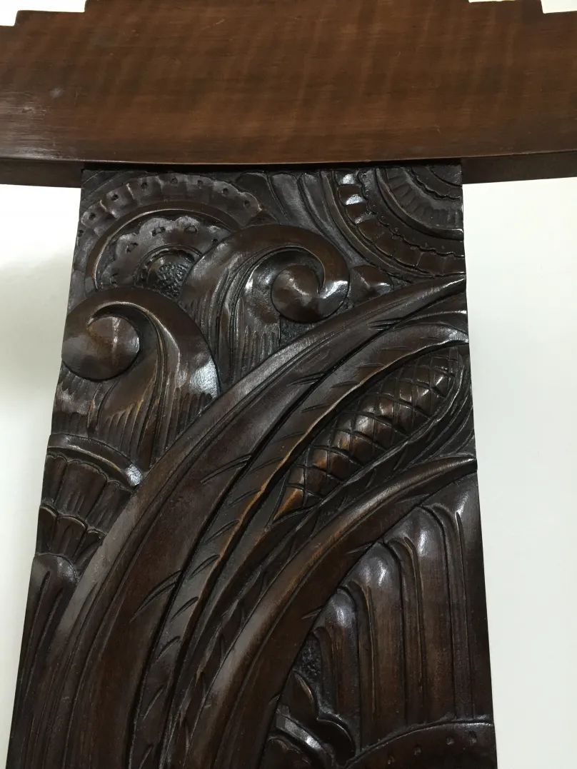 detailed view of an antique desk chair with carved design on the back
