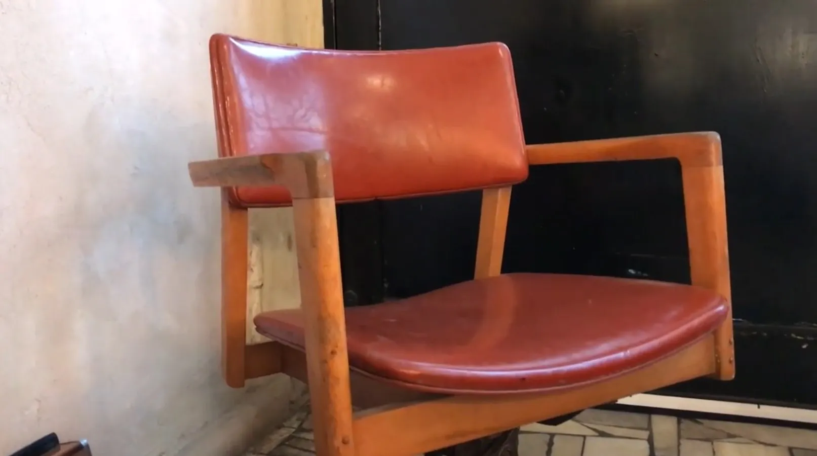 Cadeira de escritório antiga com braços e estofamento marrom