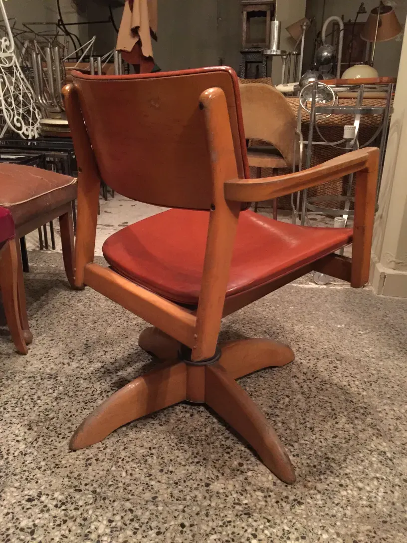 sillón de escritorio antiguo con asiento rojo y brazos, ambiente de época