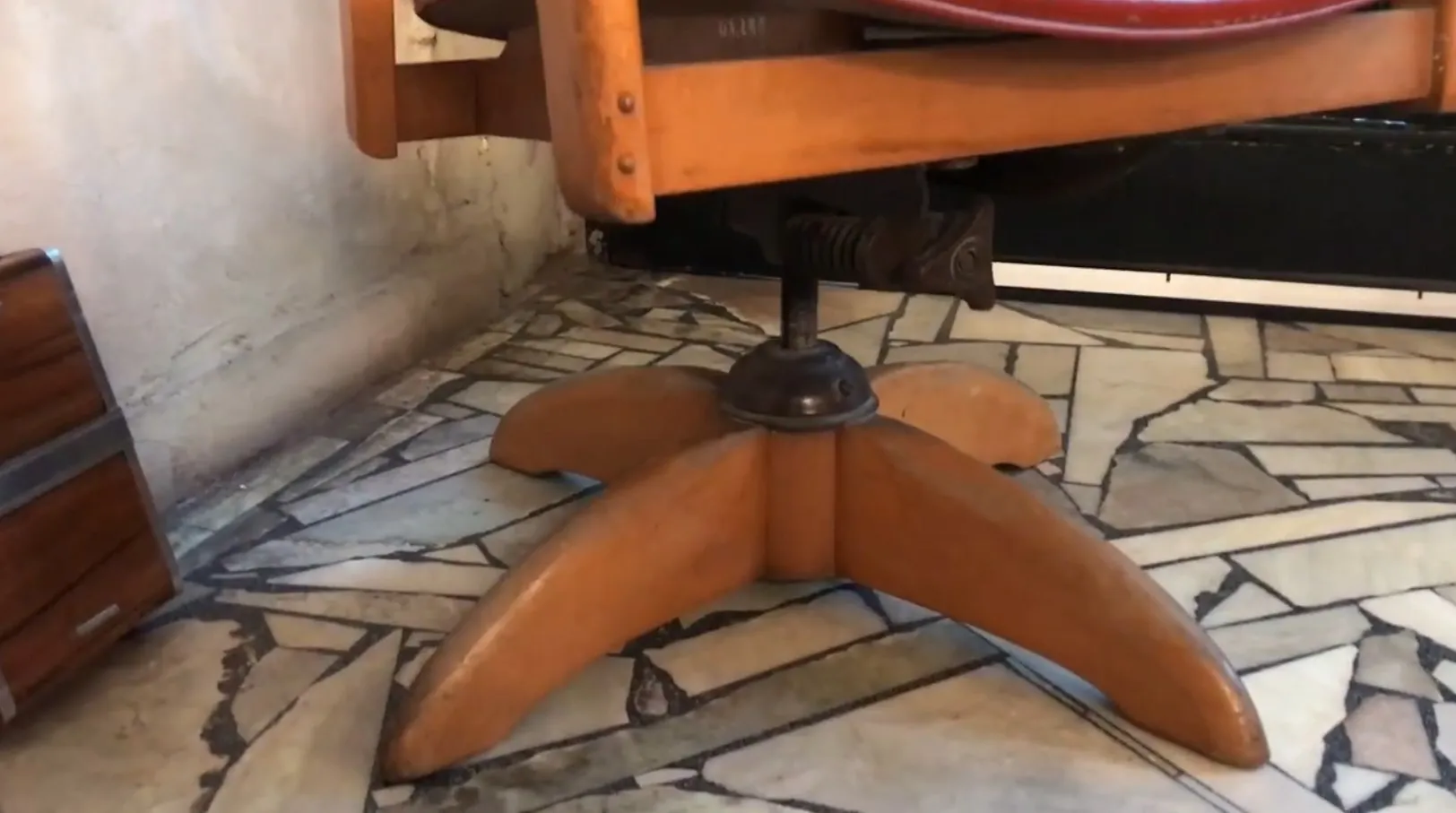 cadeira de escritório antiga com base em cruz em um ambiente acolhedor