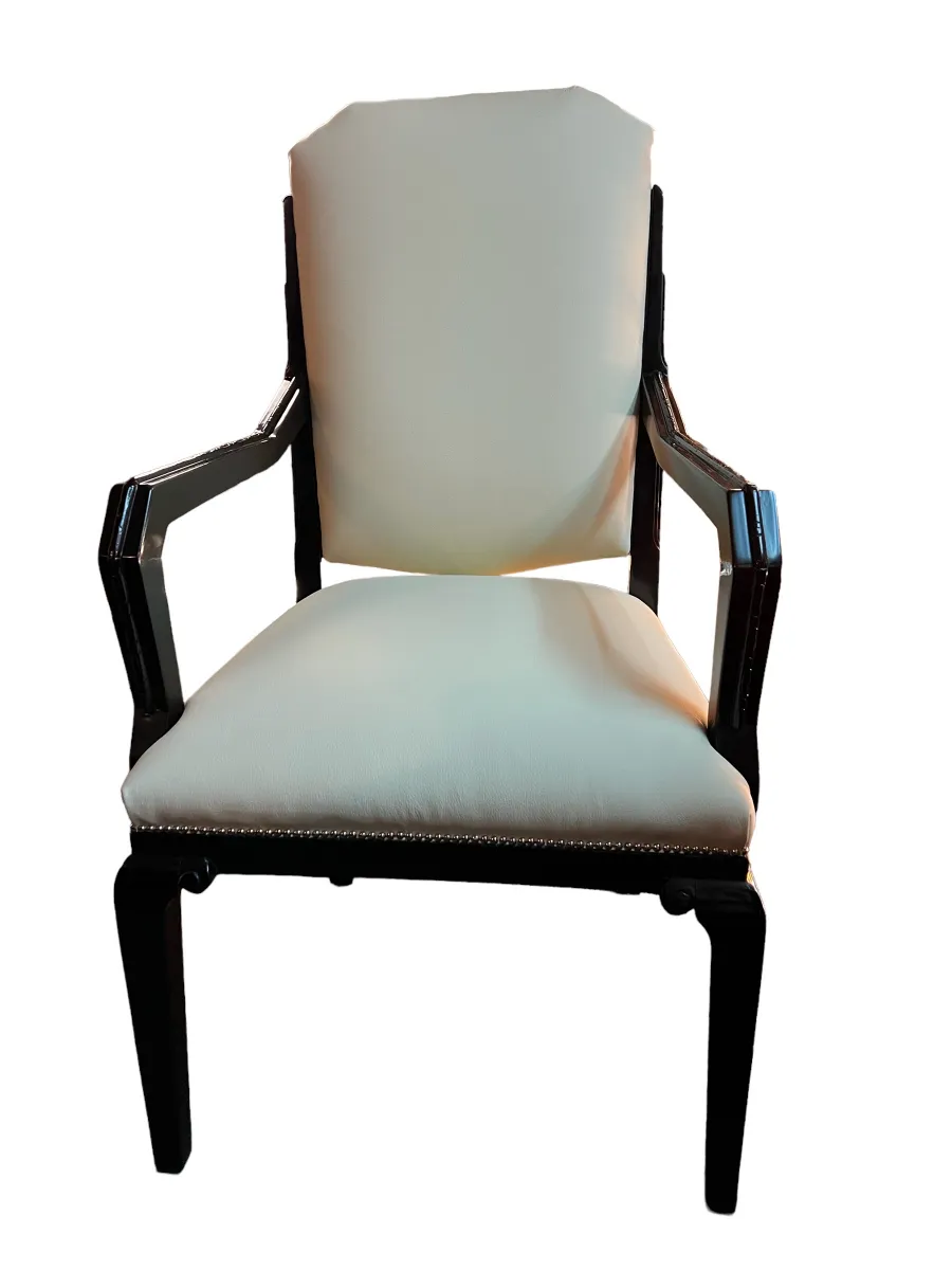 Sillón de escritorio antiguo con brazos y tapizado claro.