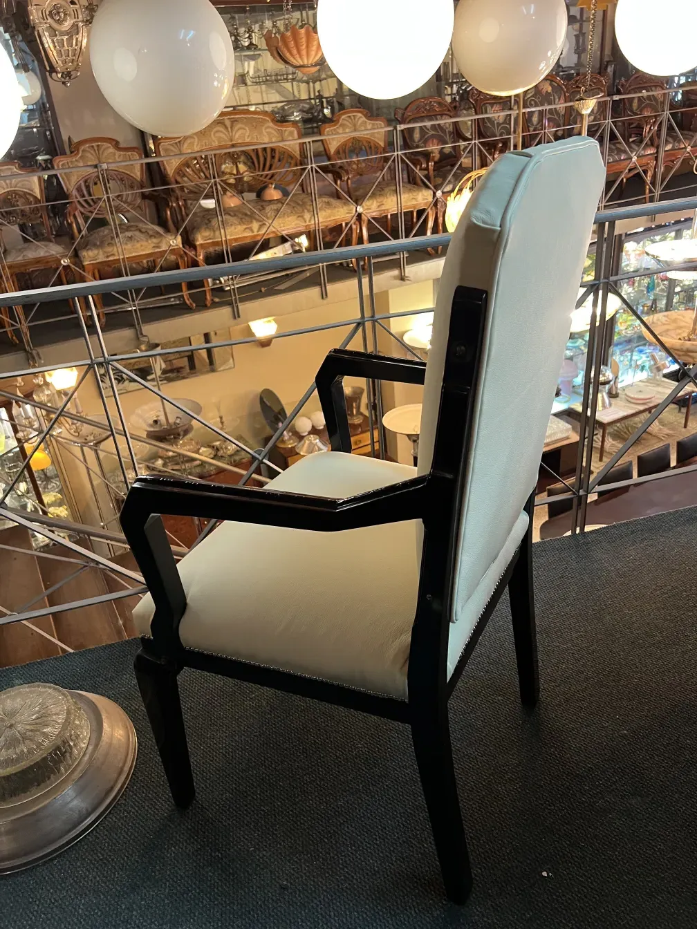 Fauteuil de bureau ancien avec coussin clair, cadre chaleureux.