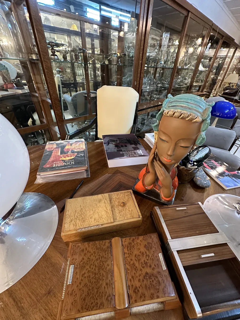 Sillón de escritorio antiguo sobre una mesa con objetos decorativos.