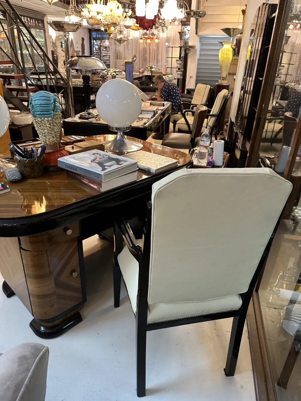 Cadeira de escritório antiga com almofada branca em um cenário decorativo com luminárias.