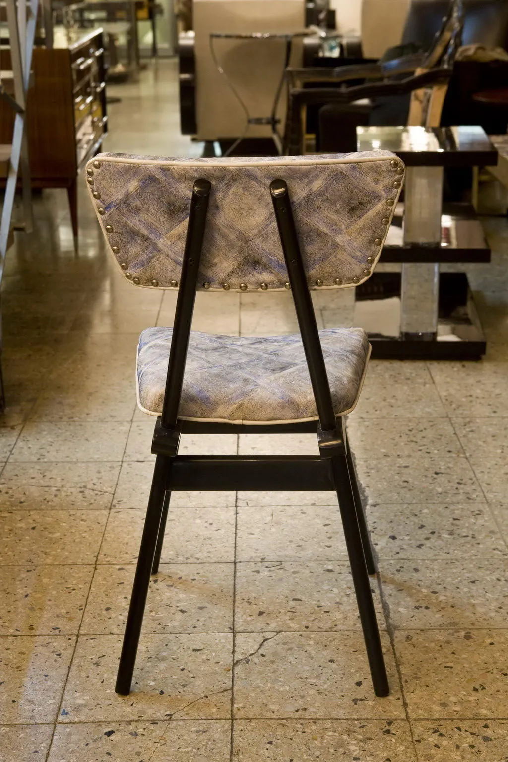 Sedie antiche con imbottitura in esposizione, sfondo moderno.