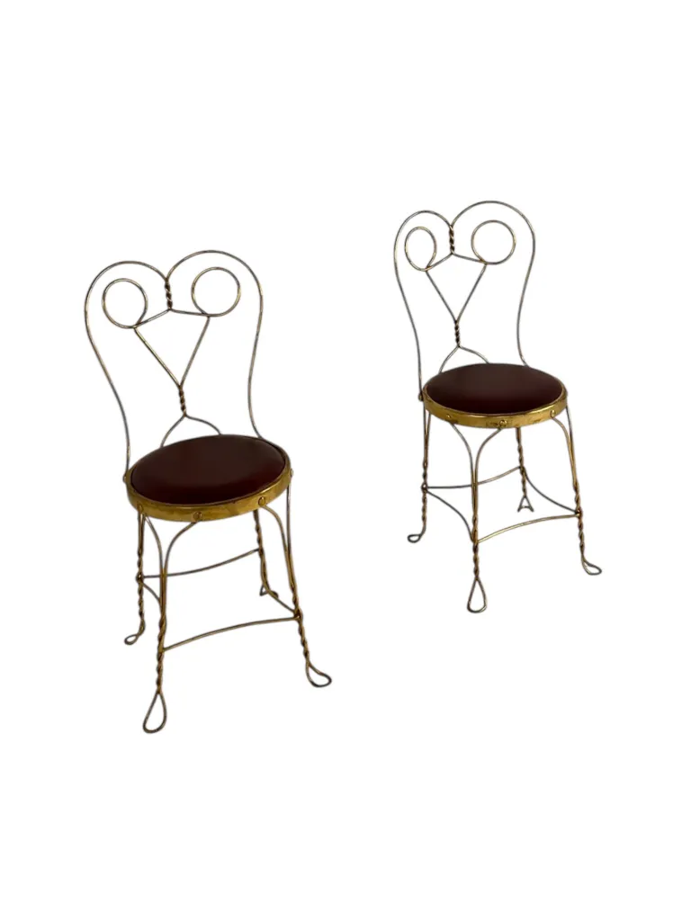 A pair of antique chairs with decorative backrest and seat, elegantly styled in a minimalist setting.