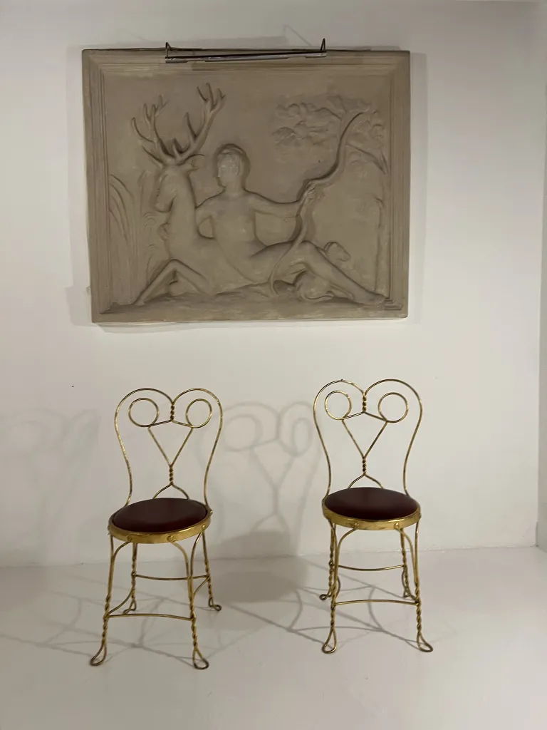 Dos sillas antiguas con diseño decorativo en un entorno minimalista