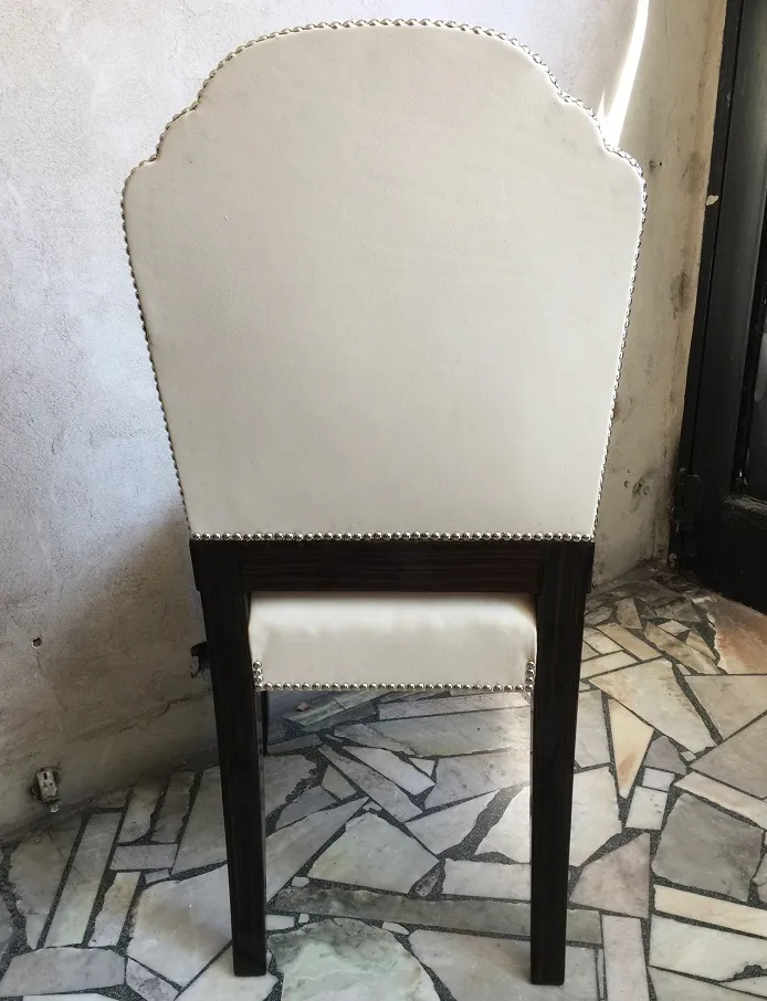 6把古老的高背椅的后视图，背景为乡村环境