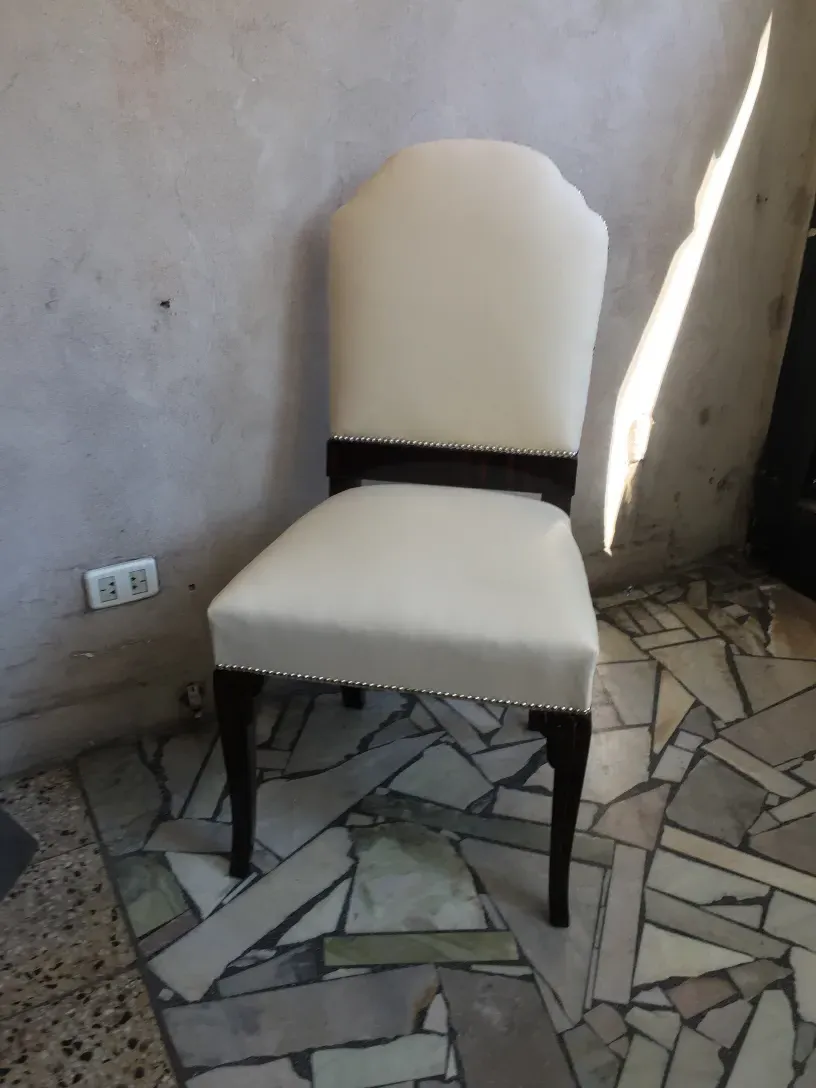 Sechs antike Stühle mit hellem Bezug in einem eleganten Ambiente.