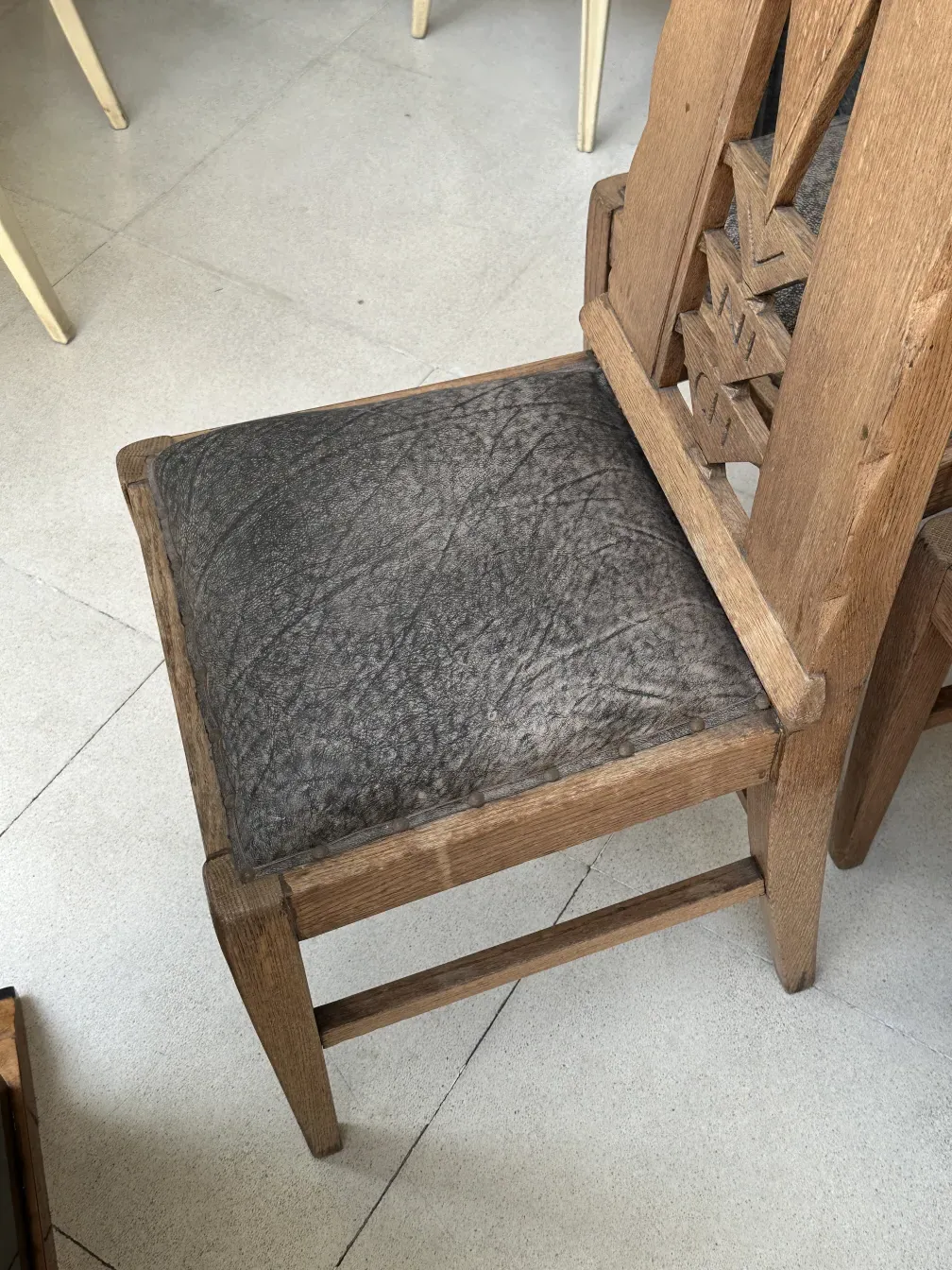 Seis cadeiras antigas Munich com design distinto em um ambiente simples.