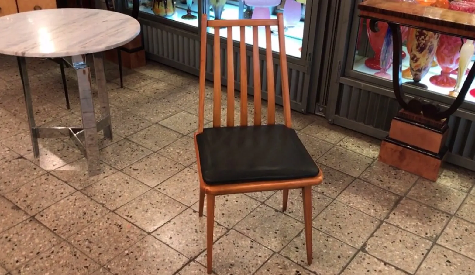 Otto sedie antiche in un ambiente con un tavolo rotondo