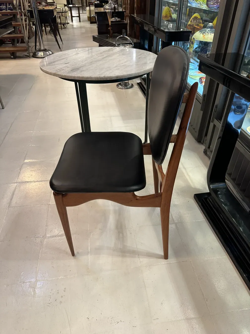 Eight antique chairs in a space with a round table, warm ambiance.