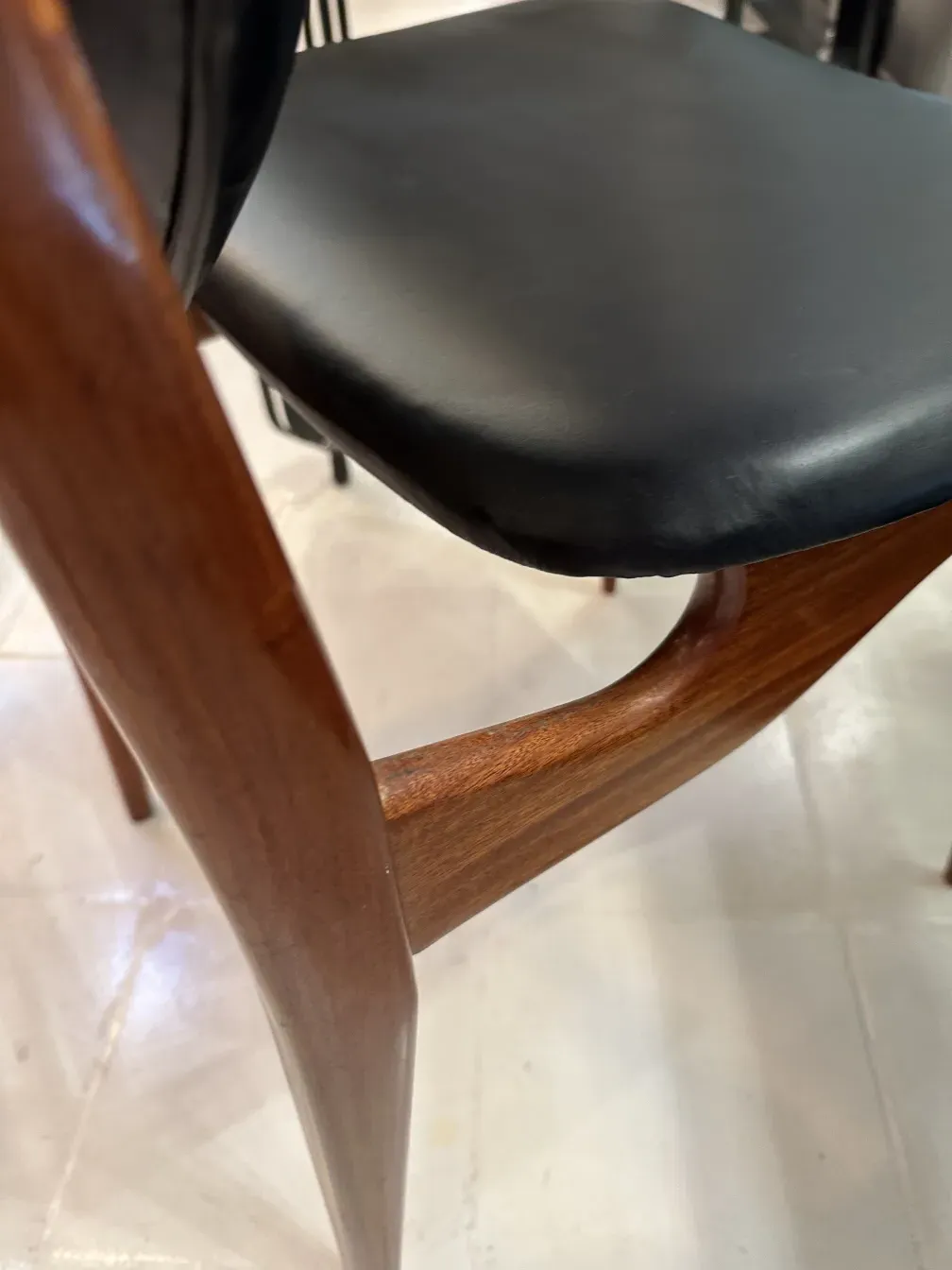 View of 8 antique finn juhl chairs in a bright setting.