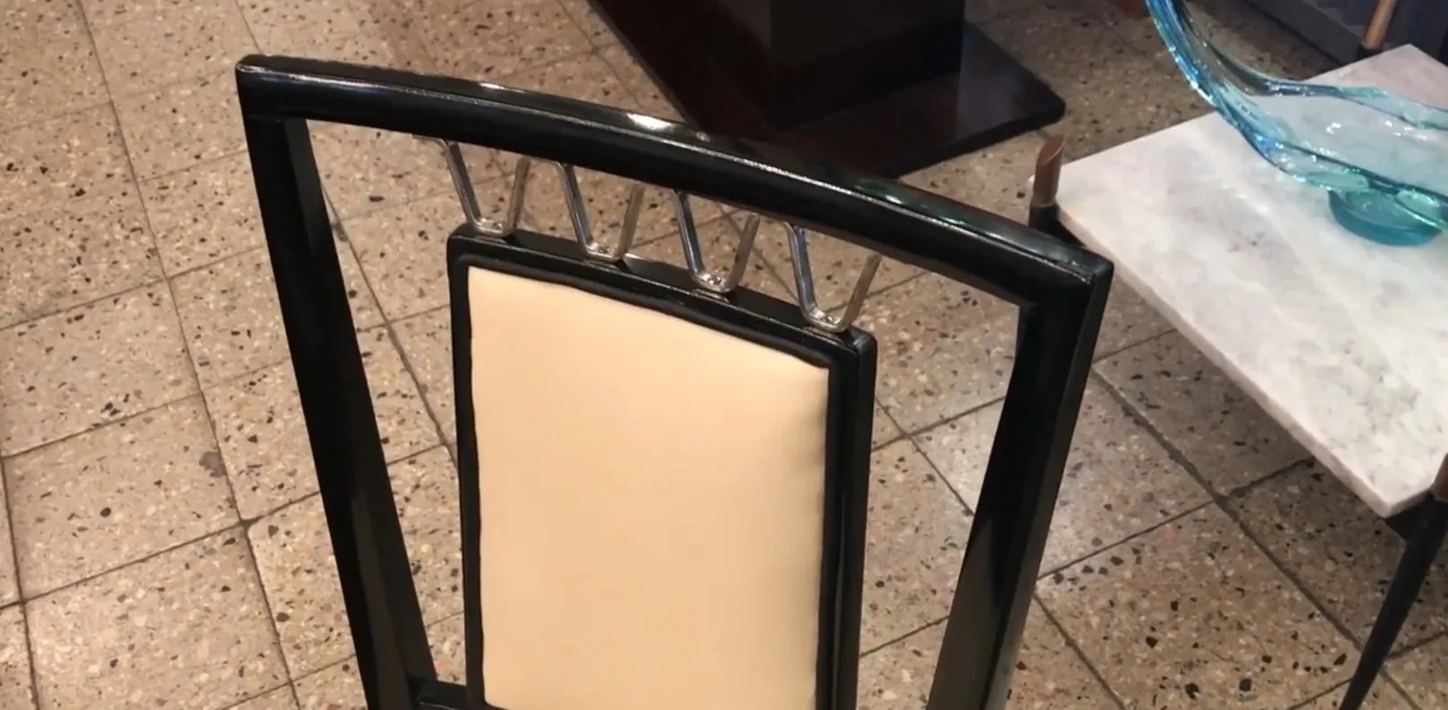 Vue détaillée d'une chaise antique avec un dossier élégant dans un cadre chaleureux.