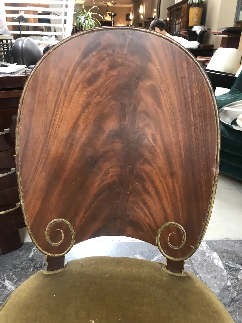 Vista de la parte trasera de una antigua silla Jansen con diseño elegante y detalles únicos en ambiente de antigüedades.