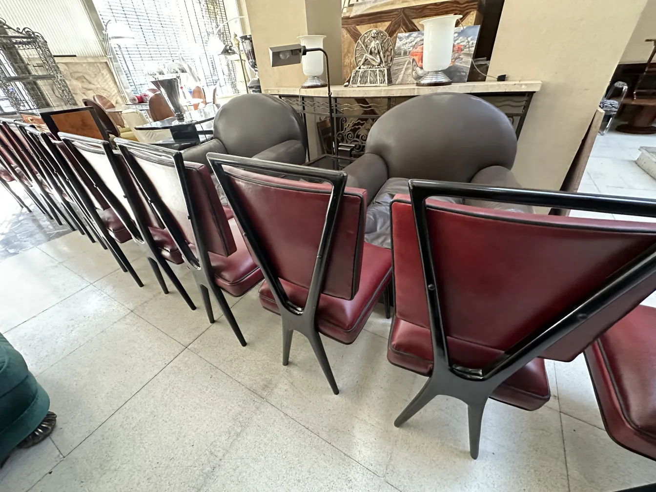 Fila de 12 cadeiras antigas elegantes em um ambiente acolhedor.