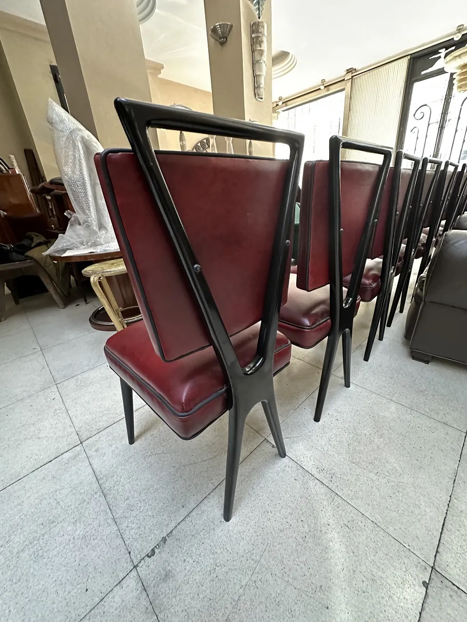 Back view of 12 antique chairs with red upholstery in an elegant setting