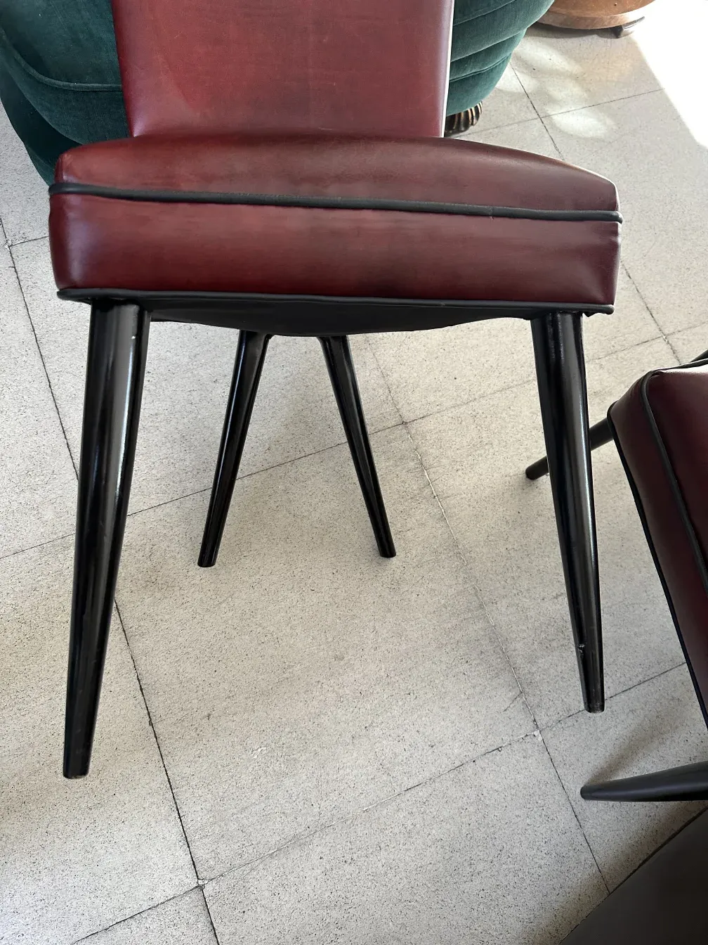 Vue latérale de 12 chaises anciennes avec un design moderne dans un cadre minimaliste.