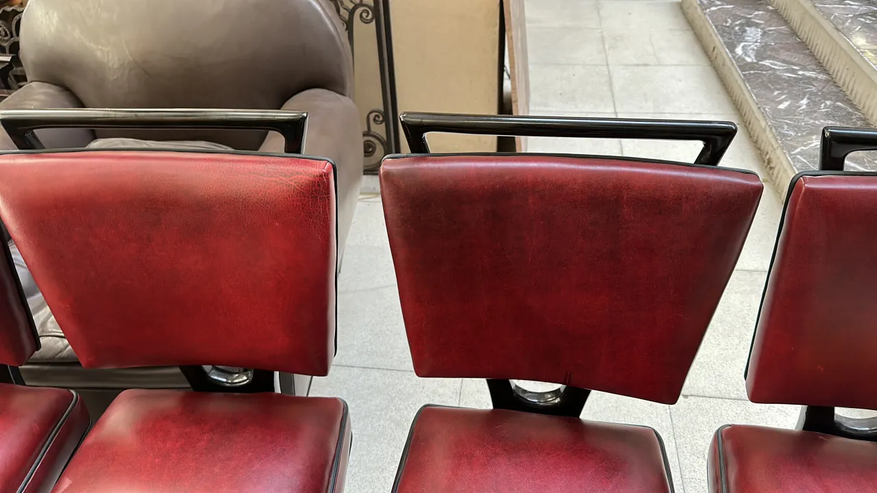 Set of 12 antique chairs with red upholstery in a decorative setting