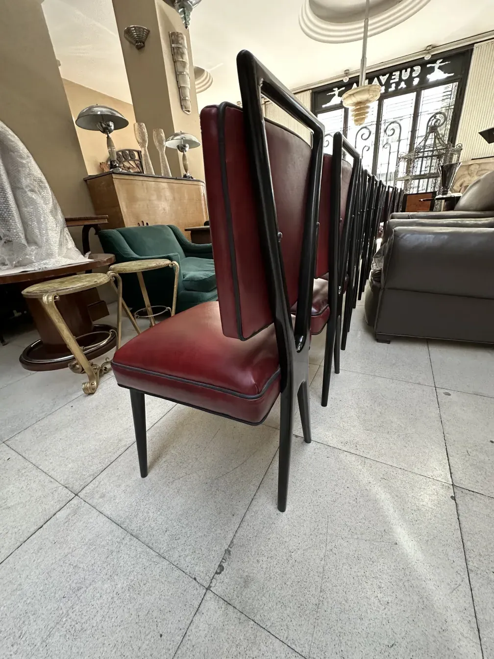 Gruppo di 12 sedie antiche in un ambiente accogliente con vari mobili.