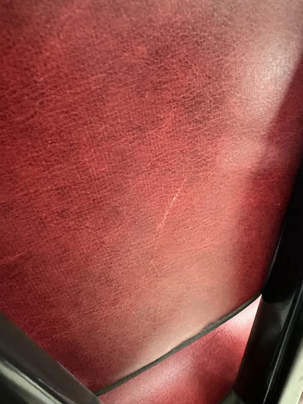 Primo piano di 12 sedie antiche in rosso scuro, parte di un ambiente classico.