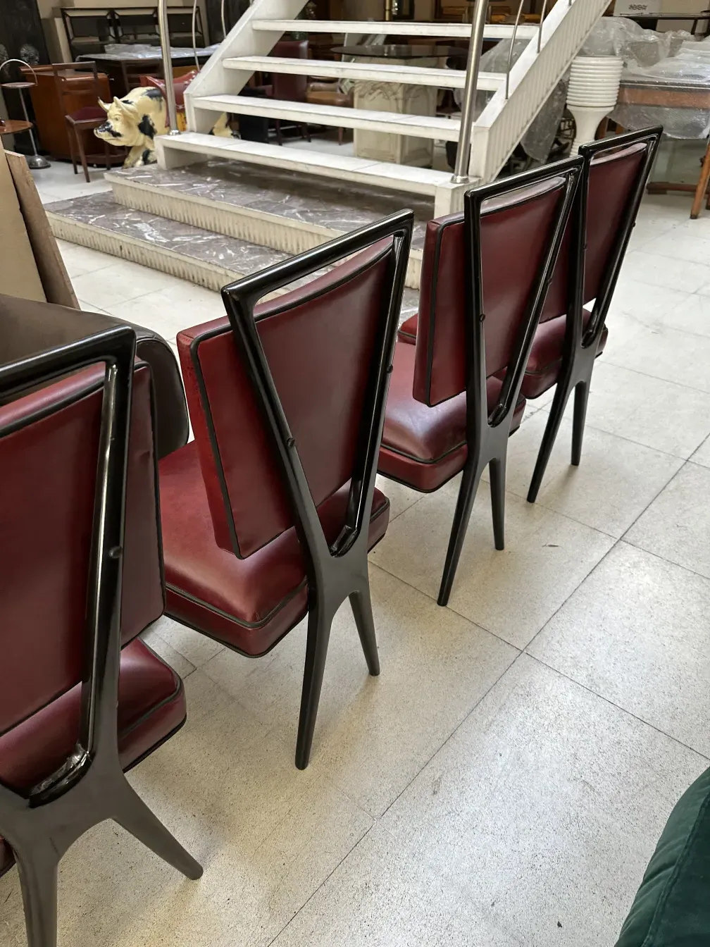 seis cadeiras antigas com estofamento vermelho e estrutura preta