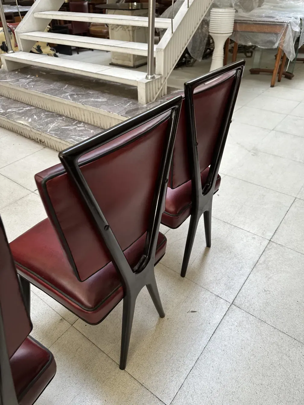 View of 12 antique chairs, burgundy color in a bright setting