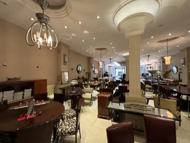 Vue d'un restaurant avec anciennes 12 chaises et tables élégantes.