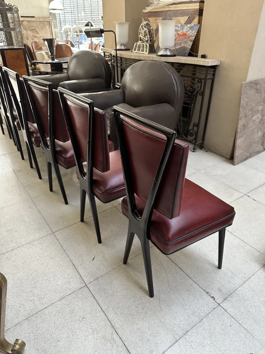 Twelve stacked chairs, red and black, in an antique setting.