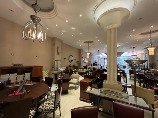 테이블로 둘러싸인 고급스러운 고대의 의자 12개를 포함한 환경 보기