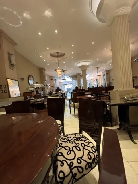 Vue de 12 chaises anciennes dans un restaurant élégant avec une décoration sophistiquée.