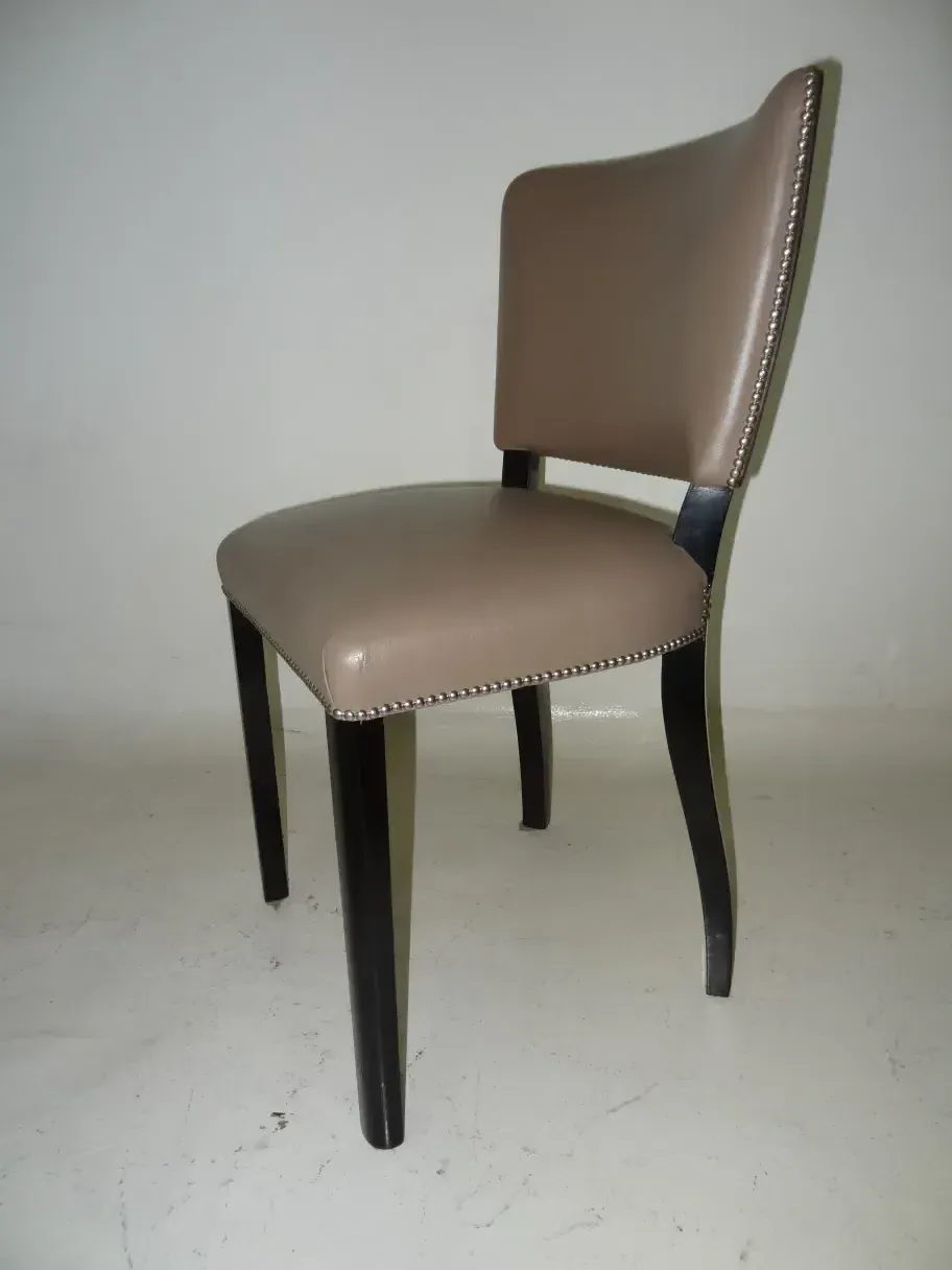 Vue latérale de 12 chaises anciennes avec un design simple.