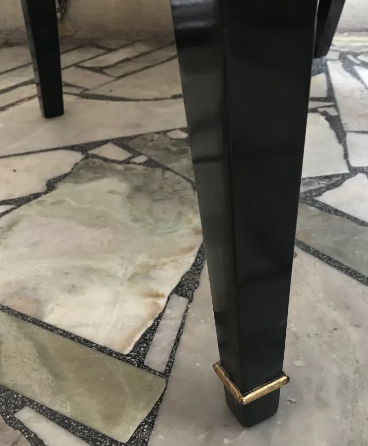 Un ensemble élégant de 12 chaises anciennes Jansen avec un design attrayant, placées sur un sol en pierre.