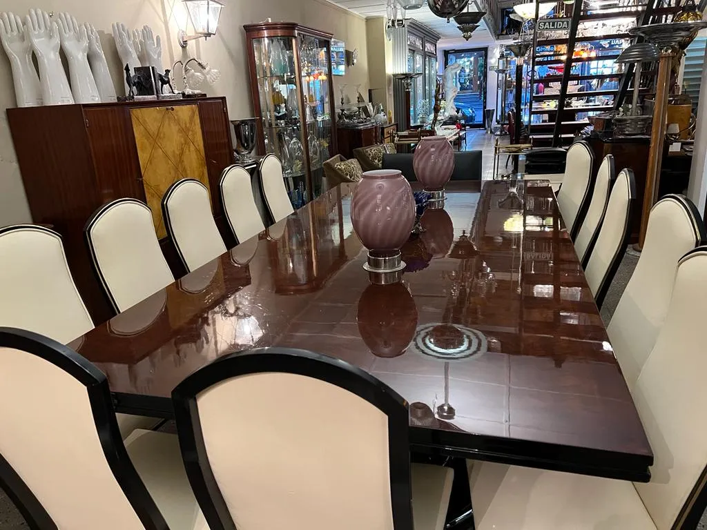 12 sillas antiguas en una mesa de comedor, decoradas con jarrones