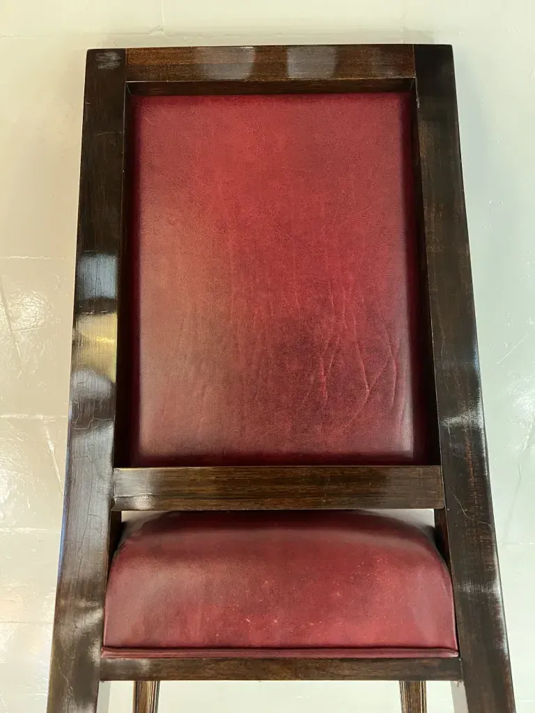 12 sedie antiche con finitura rosso scuro in un ambiente classico