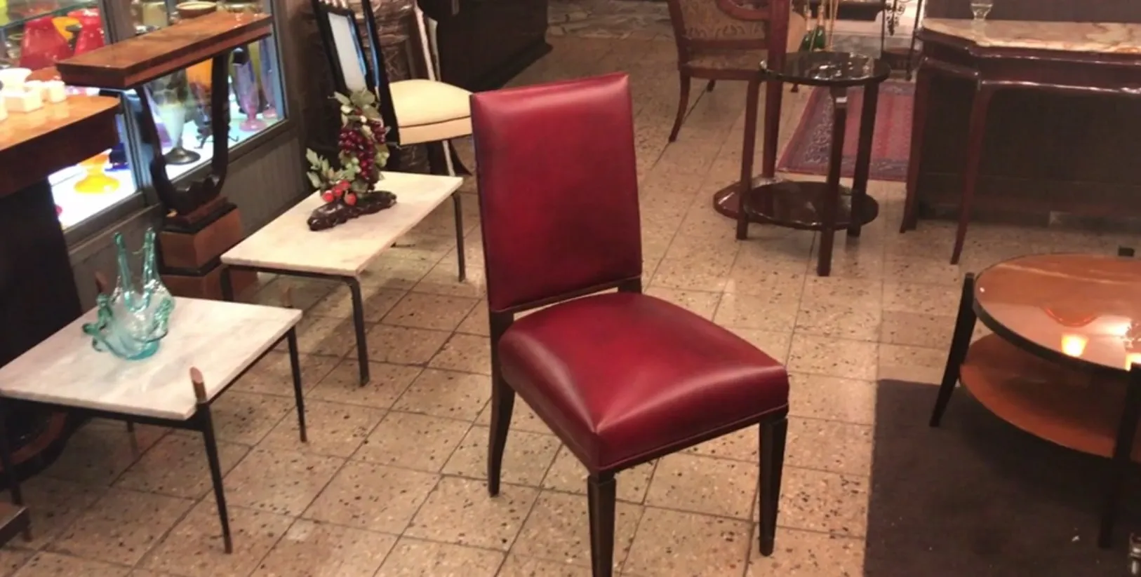 12 antique rote Stühle in einem Vintage-Ambiente