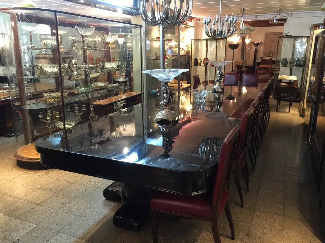 Vista de 12 sillas antiguas junto a una mesa elegante con decoraciones