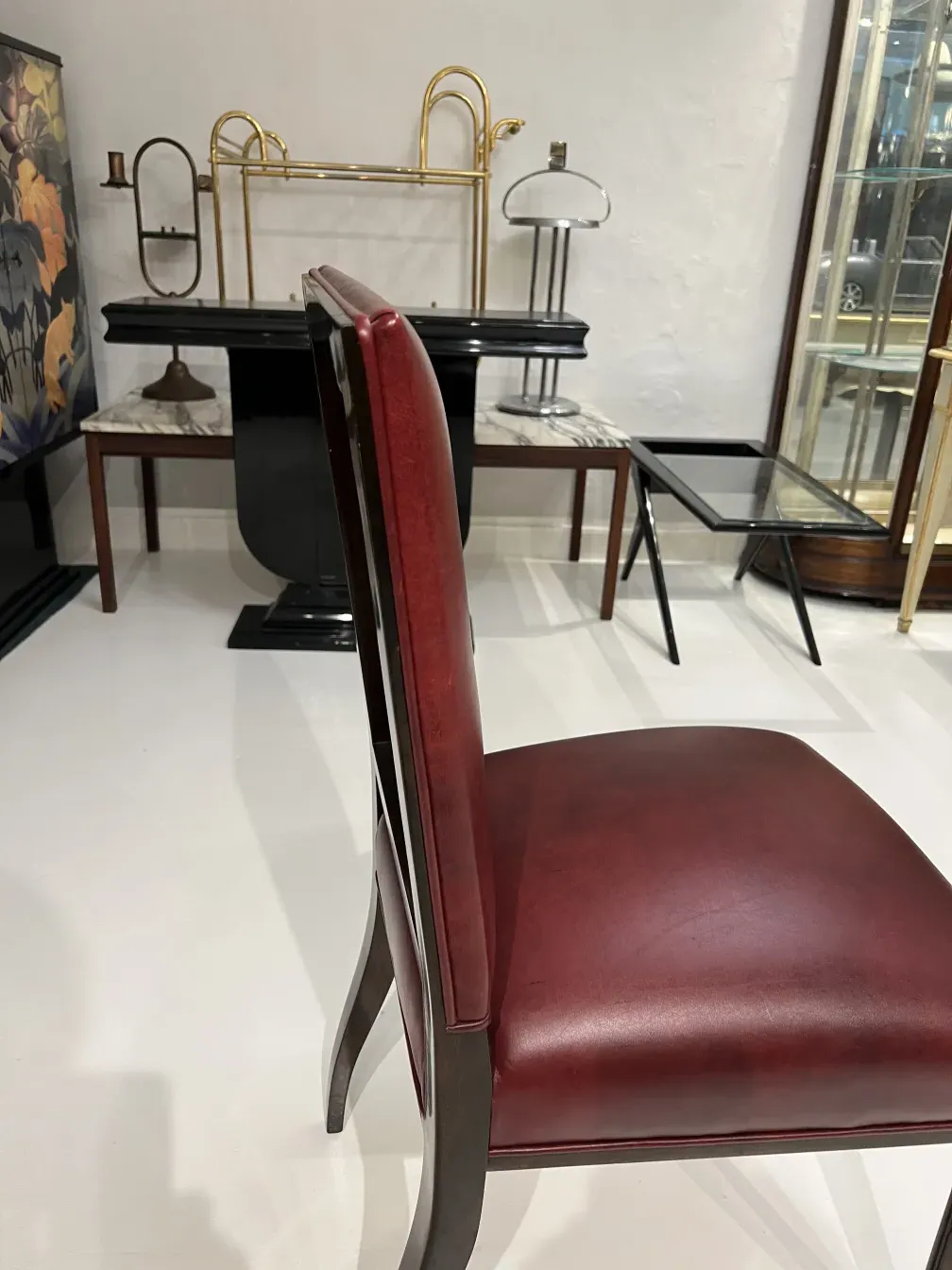 Vista di 12 eleganti sgabelli antichi in un ambiente decorativo con diversi mobili.