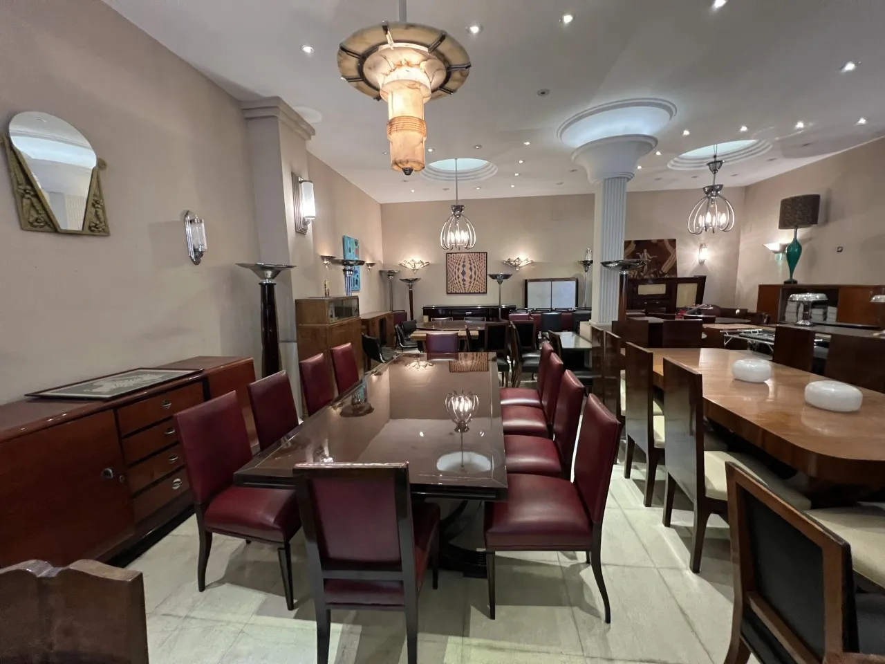 Sala de jantar com 12 cadeiras antigas, mesas e decoração elegante