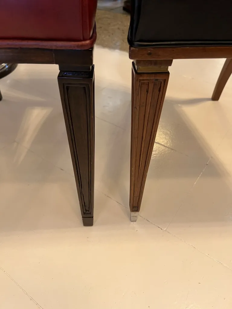 Vista di due eleganti sedie antiche, una rossa e l'altra nera, in un'atmosfera accogliente.