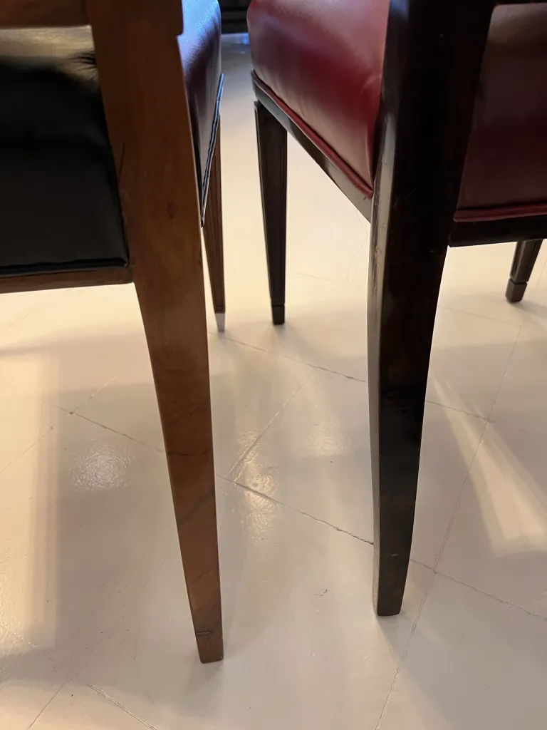 Ansicht von 12 antiken Stühlen mit schwarzen und roten Details in einem eleganten Ambiente.